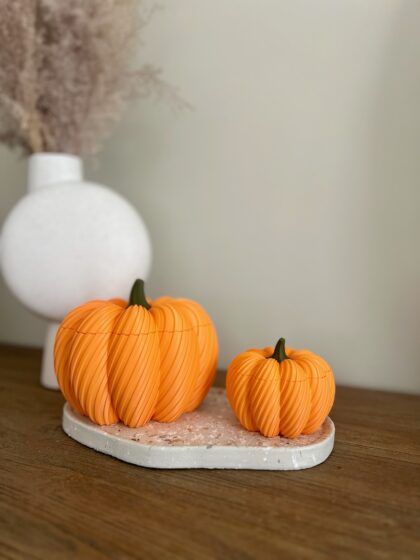 Twee 3D geprinte oranje pompoen bakjes met deksel, klein en groot, op terrazzo schaal