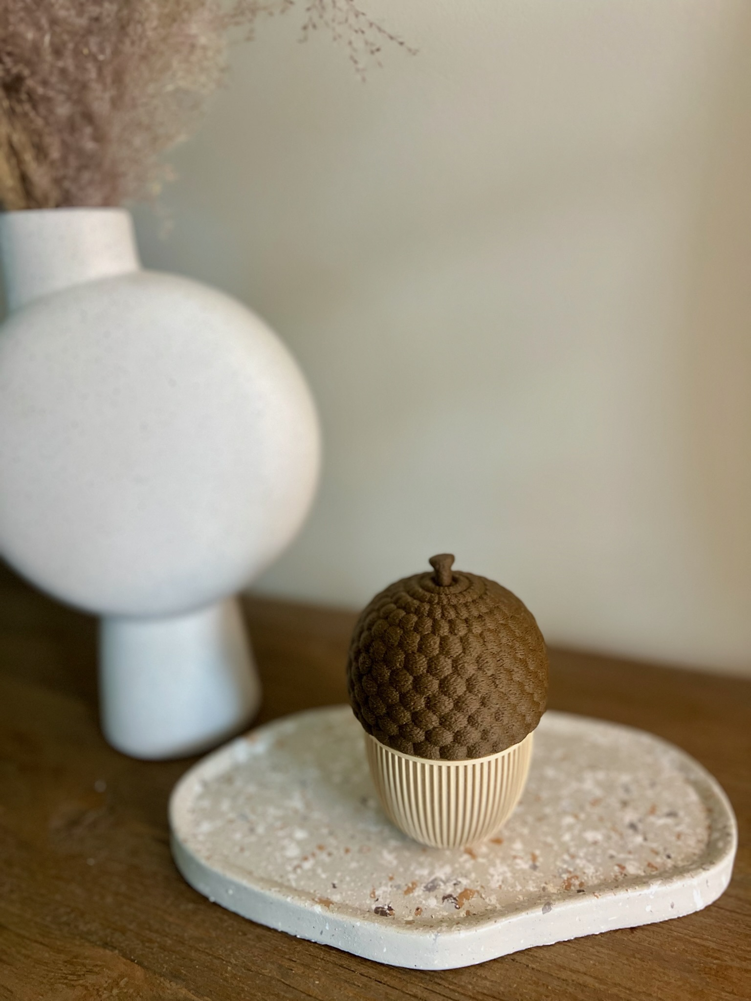 3D geprinte eikel op terrazzo schaal als herfstdecoratie